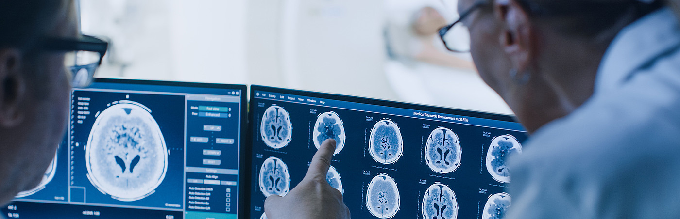 Ärzte blicken auf Monitore mit radiologischen Abbildungen